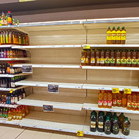 Un rayon huile de supermarché avec beaucoup de produits absents
